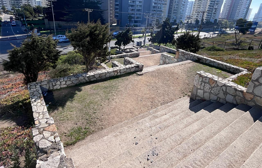 Vista desde arriba de la Escalera Las Pelargonias mostrando los descansos escalonados de maicillo y muros de piedra, con edificios al fondo